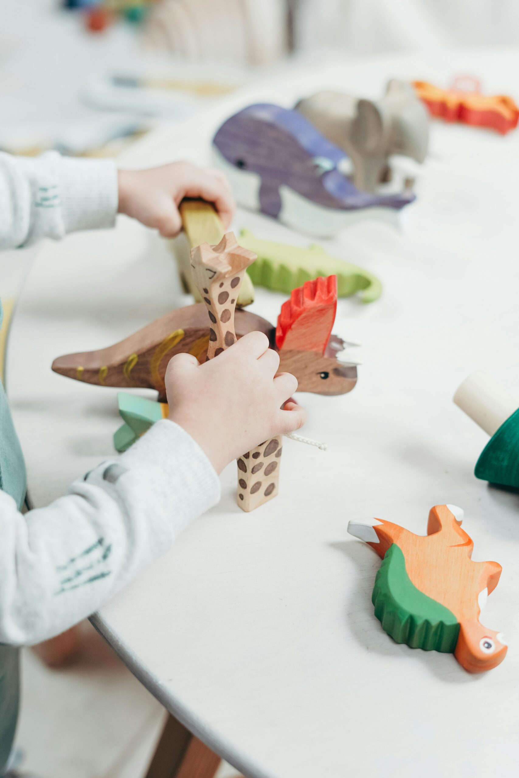 pexels-photo-3661264-3661264 A young child creatively plays with colorful wooden toys on a table, fostering imagination and learning.