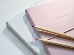 pexels-photo-1018133-1018133 Close-up of a pink journal with pencils on a marble top. Perfect for note-taking or planning.